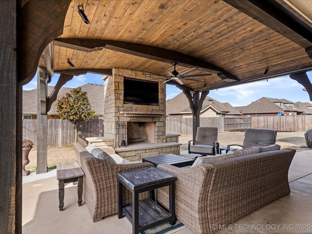 view of patio featuring an outdoor living space with a fireplace and a fenced backyard