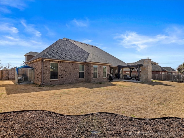 rear view of house featuring a patio, brick siding, a fenced backyard, and a pergola