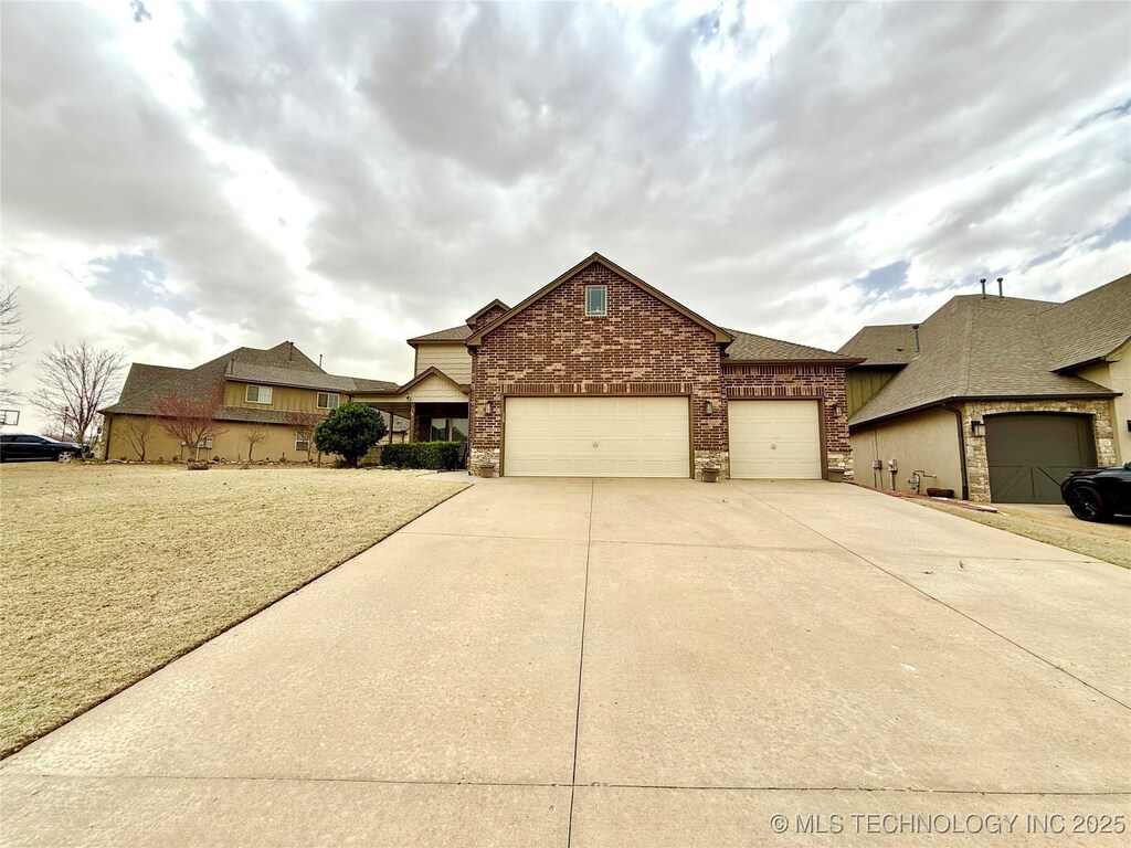 view of front of property with an attached garage, concrete driveway, and brick siding