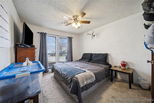 carpeted bedroom featuring visible vents, a textured ceiling, and a ceiling fan