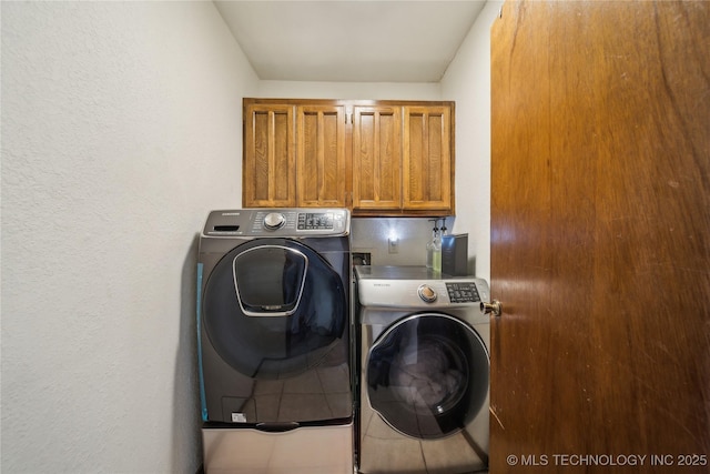 clothes washing area featuring separate washer and dryer and cabinet space