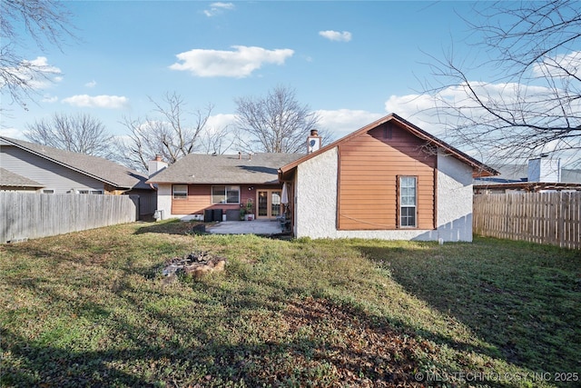 rear view of house with a patio area, a lawn, and a fenced backyard