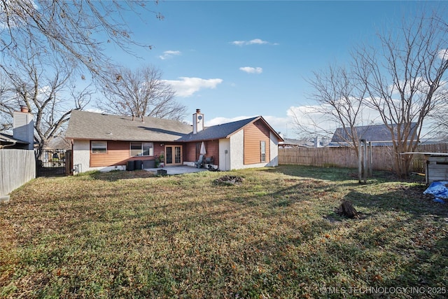 back of house featuring a fenced backyard, french doors, a yard, and a patio