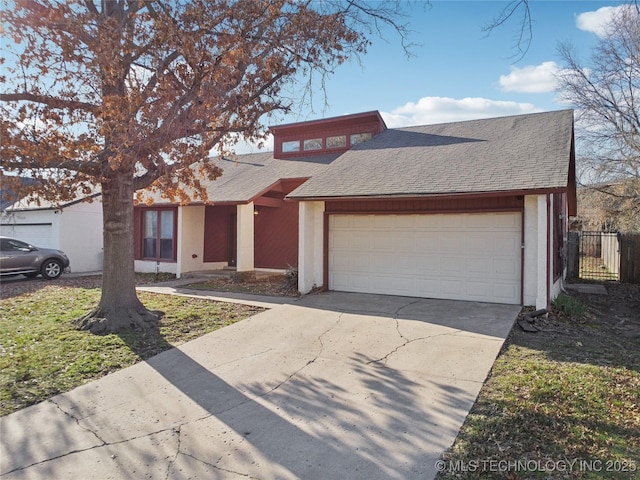 view of front of property featuring fence, driveway, roof with shingles, stucco siding, and a garage