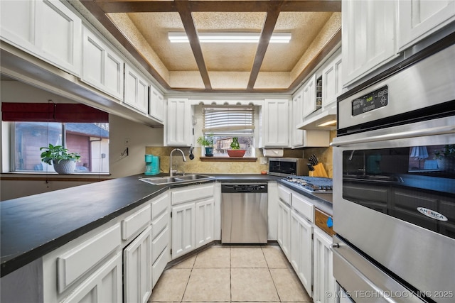 kitchen featuring a sink, dark countertops, white cabinetry, and stainless steel appliances