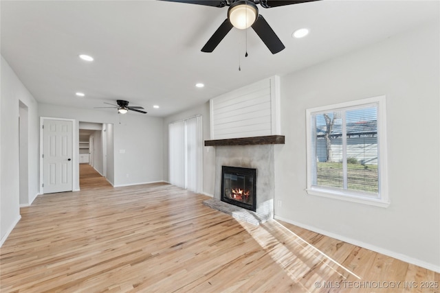 unfurnished living room featuring recessed lighting, a fireplace, light wood-type flooring, and a ceiling fan