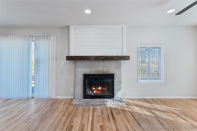 room details featuring wood finished floors, recessed lighting, a large fireplace, baseboards, and ceiling fan