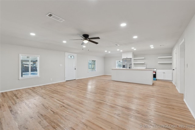 unfurnished living room with light wood-type flooring, visible vents, ceiling fan, and recessed lighting