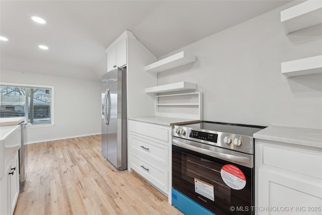 kitchen featuring open shelves, white cabinets, light countertops, and stainless steel appliances