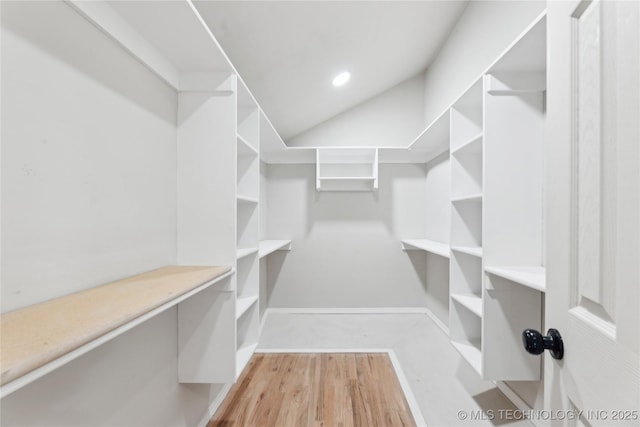 spacious closet featuring vaulted ceiling and wood finished floors