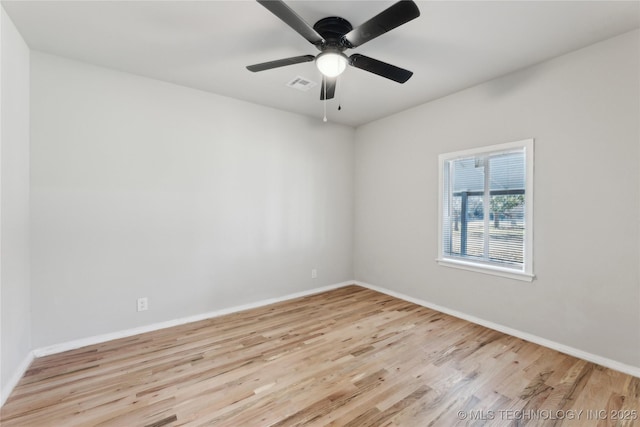 empty room with ceiling fan, wood finished floors, visible vents, and baseboards