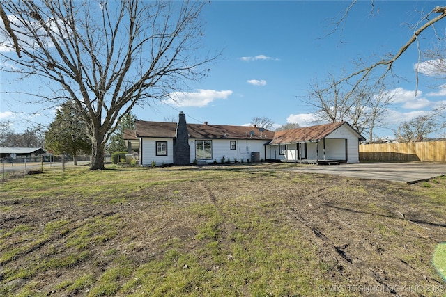 view of front of home with a chimney, a front yard, and fence