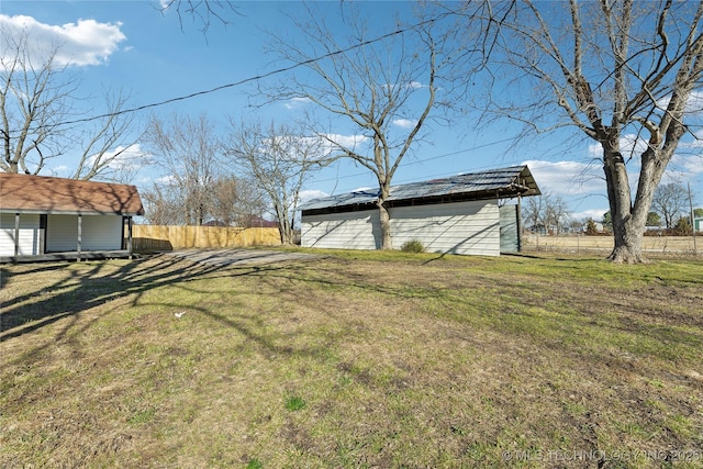 view of yard featuring an outdoor structure and fence