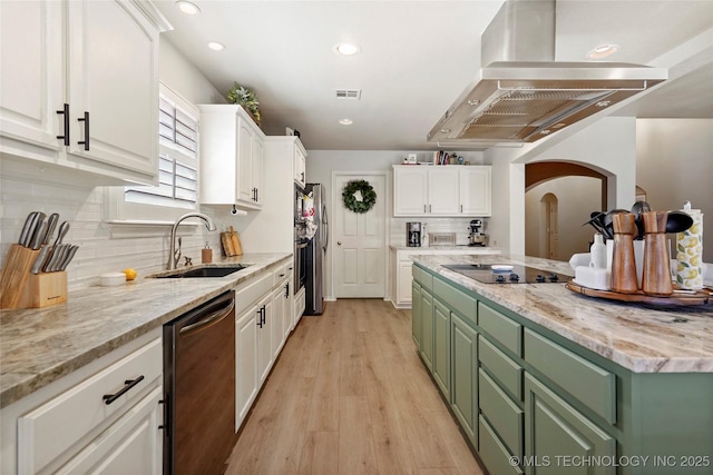 kitchen featuring island range hood, black appliances, green cabinets, and a sink