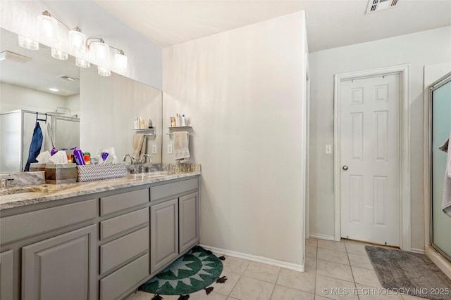 bathroom featuring tile patterned floors, visible vents, a sink, a shower stall, and double vanity