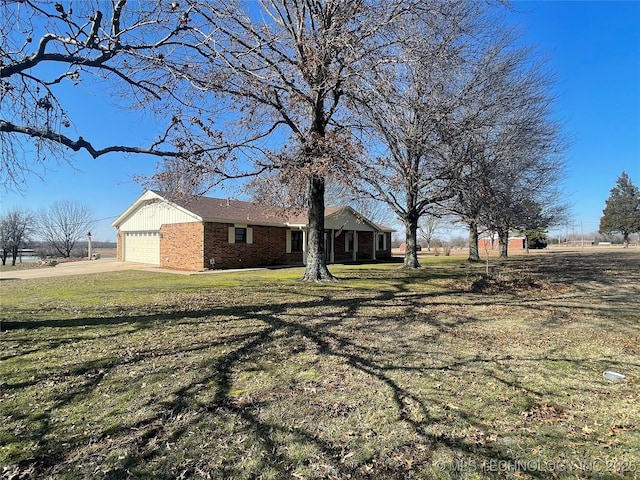 view of yard with concrete driveway and a garage