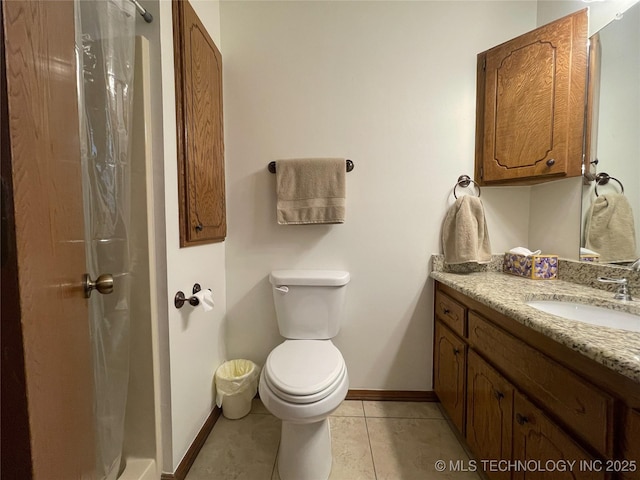 bathroom with vanity, toilet, baseboards, and tile patterned flooring