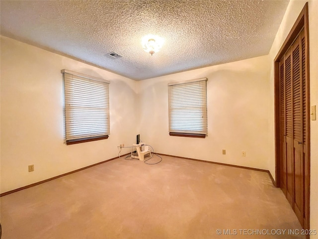 unfurnished bedroom with a closet, visible vents, baseboards, and carpet floors