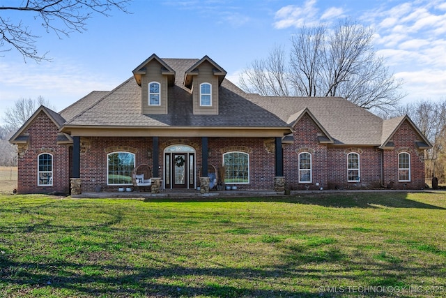 view of front facade with a front lawn, brick siding, and a shingled roof