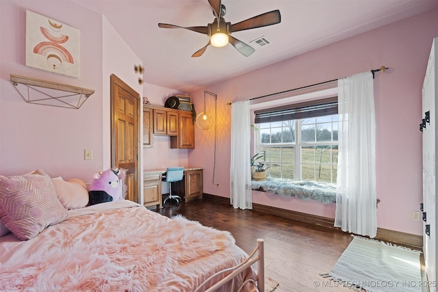 bedroom with visible vents, baseboards, dark wood-type flooring, and ceiling fan