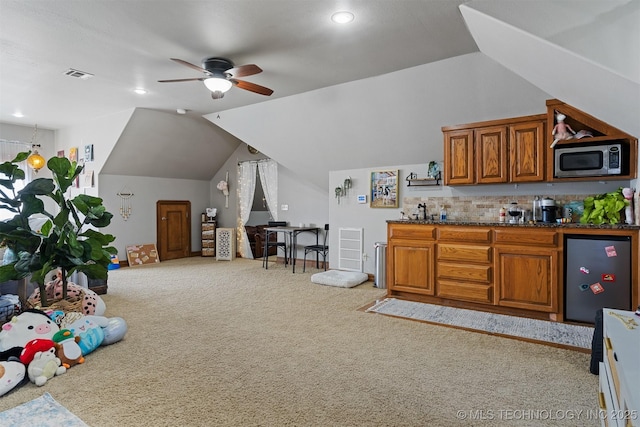 kitchen with visible vents, stainless steel microwave, ceiling fan, carpet floors, and brown cabinets