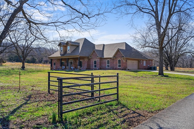 view of front of home with brick siding, a front lawn, a fenced front yard, driveway, and an attached garage