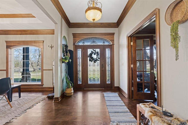 foyer featuring baseboards, wood finished floors, and ornamental molding