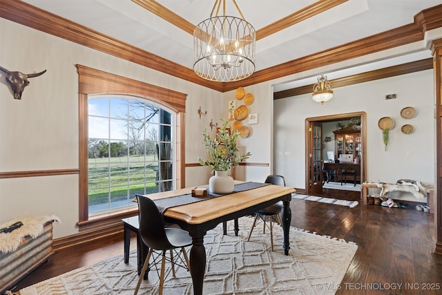 dining space with a tray ceiling, a chandelier, wood-type flooring, and ornamental molding