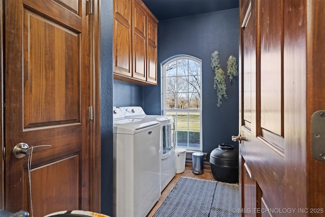 laundry area featuring cabinet space, washing machine and dryer, and a textured wall