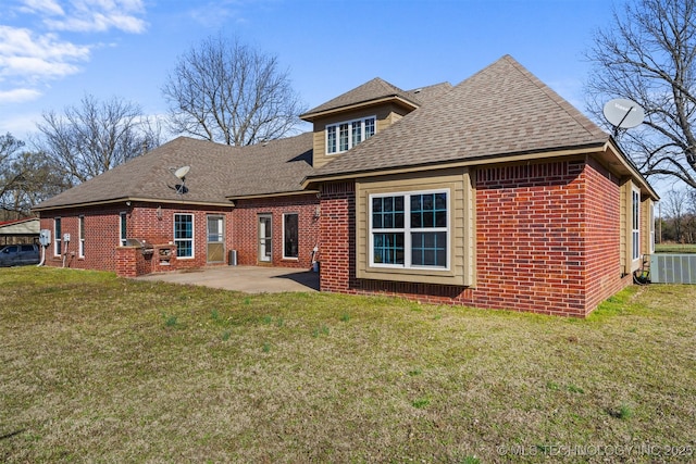 rear view of house with a patio area, brick siding, roof with shingles, and a lawn