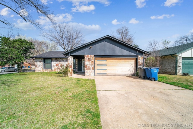view of front of property with stone siding, driveway, an attached garage, and a front lawn