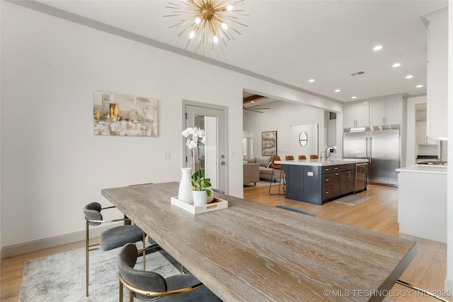 dining space featuring light wood-style flooring, recessed lighting, baseboards, a chandelier, and vaulted ceiling