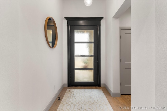 foyer with baseboards and light wood-style floors