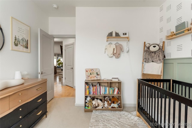 bedroom with baseboards and a nursery area