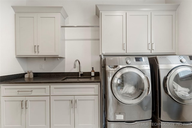 clothes washing area featuring a sink, cabinet space, and washing machine and clothes dryer