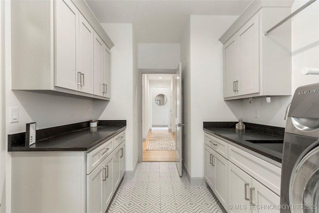 laundry room featuring cabinet space and baseboards