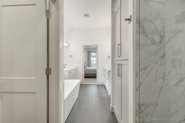 bathroom with visible vents, a walk in shower, ensuite bath, a freestanding bath, and vanity