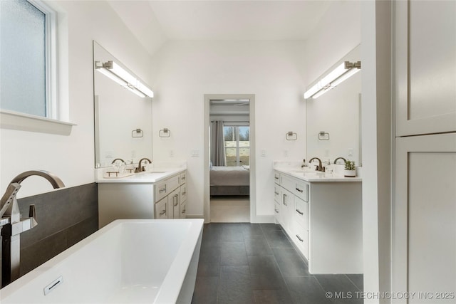 bathroom with tile patterned flooring, connected bathroom, vanity, and a freestanding tub