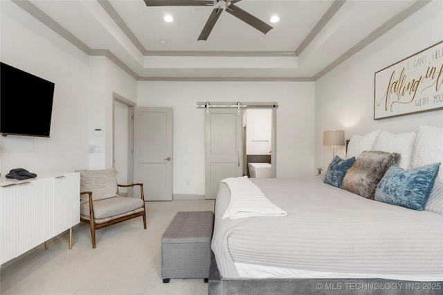 bedroom with recessed lighting, a barn door, light colored carpet, and a tray ceiling