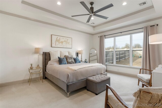 bedroom with visible vents, a raised ceiling, light colored carpet, and baseboards