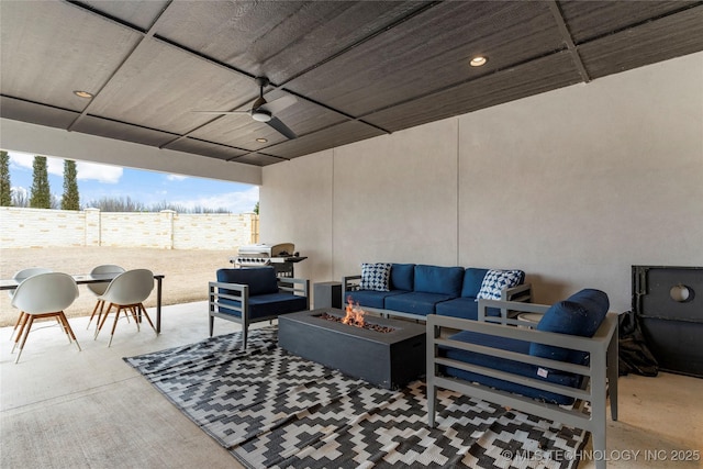 view of patio / terrace with an outdoor living space with a fire pit, fence, and ceiling fan