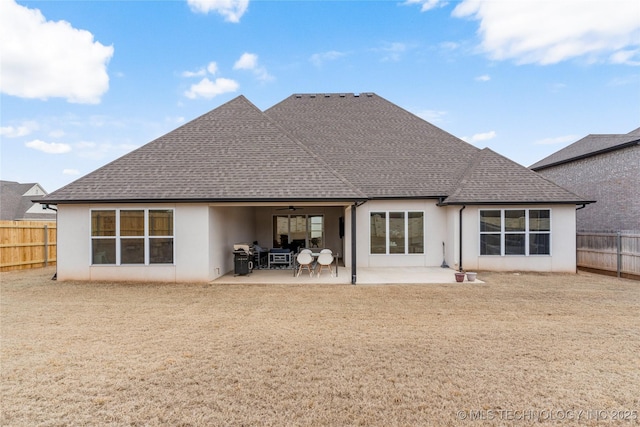 rear view of house with stucco siding, a patio, a fenced backyard, a shingled roof, and ceiling fan