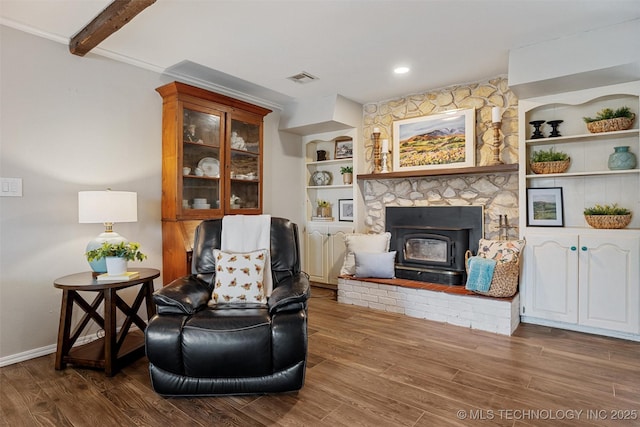 sitting room with visible vents, beam ceiling, and wood finished floors