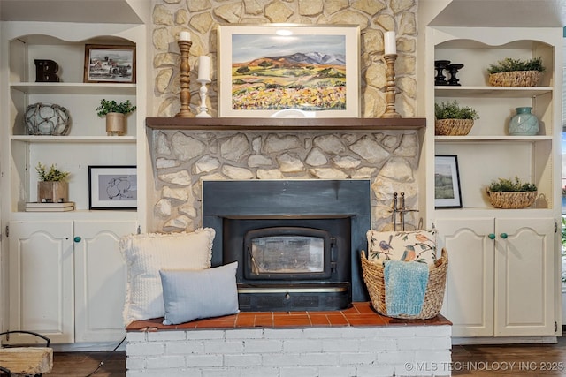 room details with a wood stove, built in shelves, and wood finished floors