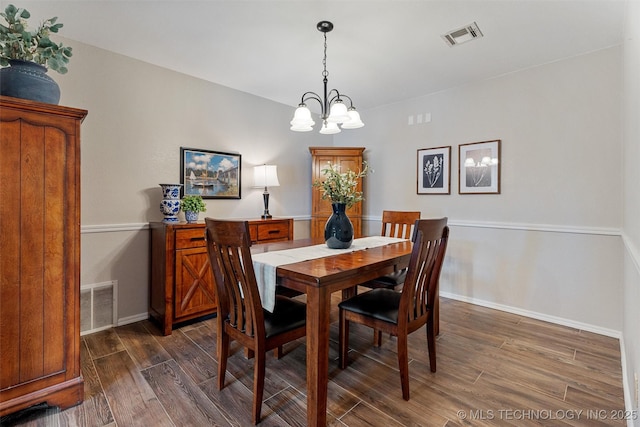 dining area with dark wood-style floors, visible vents, baseboards, and an inviting chandelier