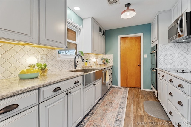 kitchen with visible vents, white cabinets, stainless steel appliances, and a sink