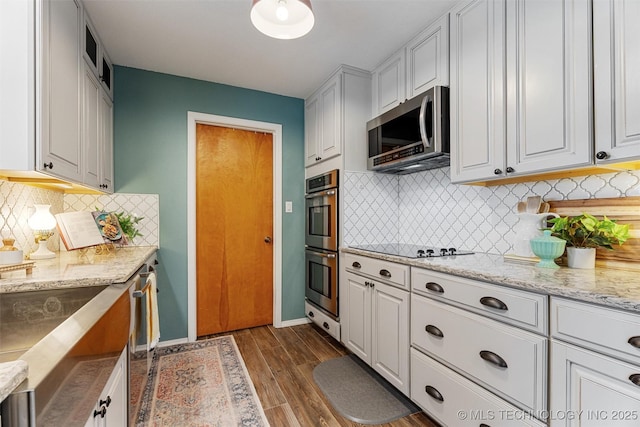 kitchen featuring dark wood-type flooring, baseboards, light stone countertops, white cabinets, and stainless steel appliances