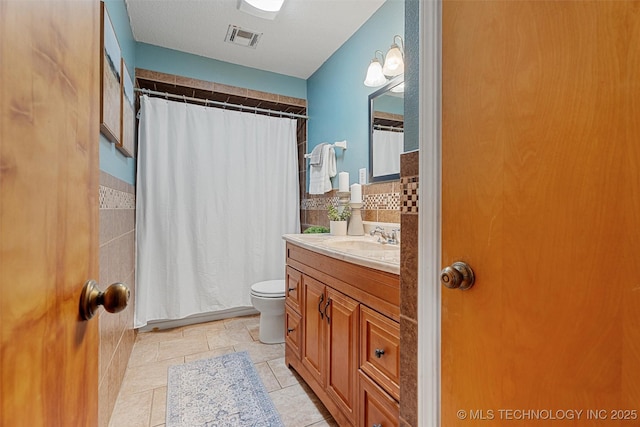 bathroom featuring toilet, a shower with curtain, vanity, and visible vents