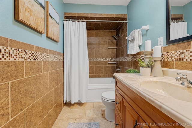 full bathroom featuring toilet, tile walls, vanity, and shower / bath combo