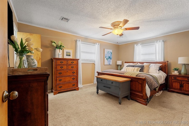 bedroom with visible vents, ceiling fan, ornamental molding, carpet floors, and a textured ceiling